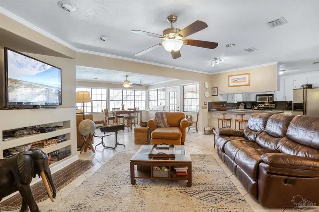 a living room with furniture kitchen view and a flat screen tv