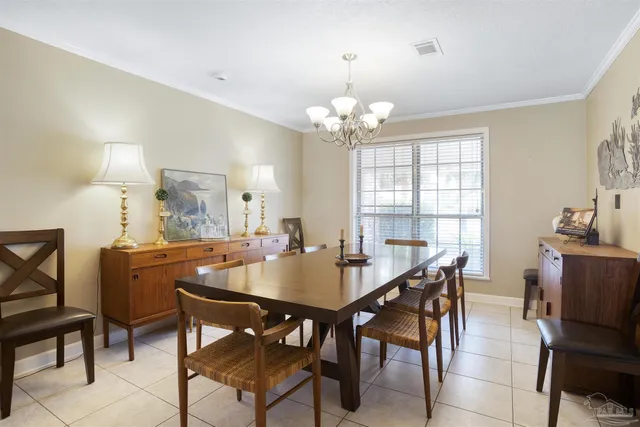 a view of a dining room with furniture a chandelier and wooden floor