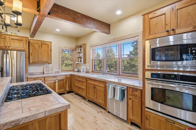 a kitchen with stainless steel appliances a stove a sink and a microwave