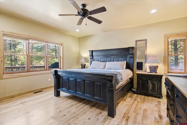 a bed sitting in a spacious bedroom next to a window