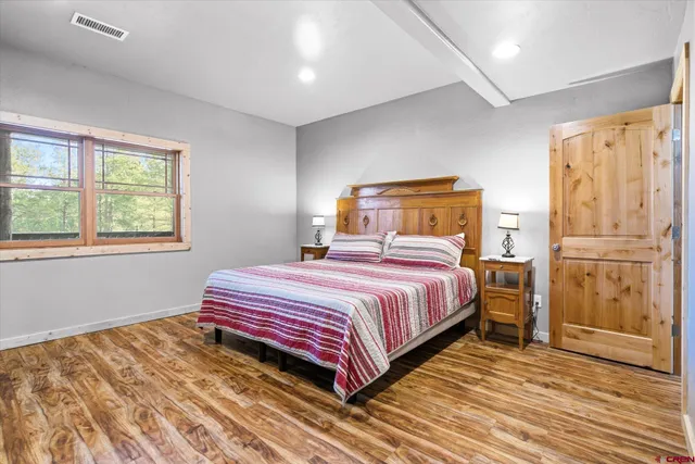 a bedroom with a bed and wooden floor