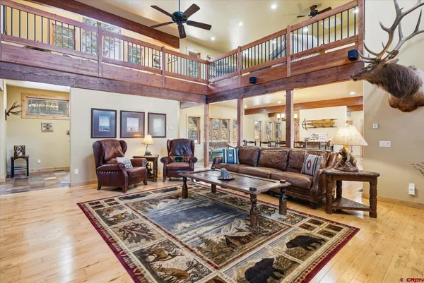 a living room with stainless steel appliances furniture and a kitchen view