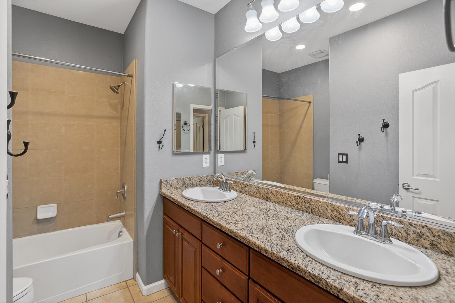 2042 Danforth Way Plumas Lake, CA 95961 - Photo 29 of 56 a bathroom with a granite countertop sink a mirror a shower and a bathtub