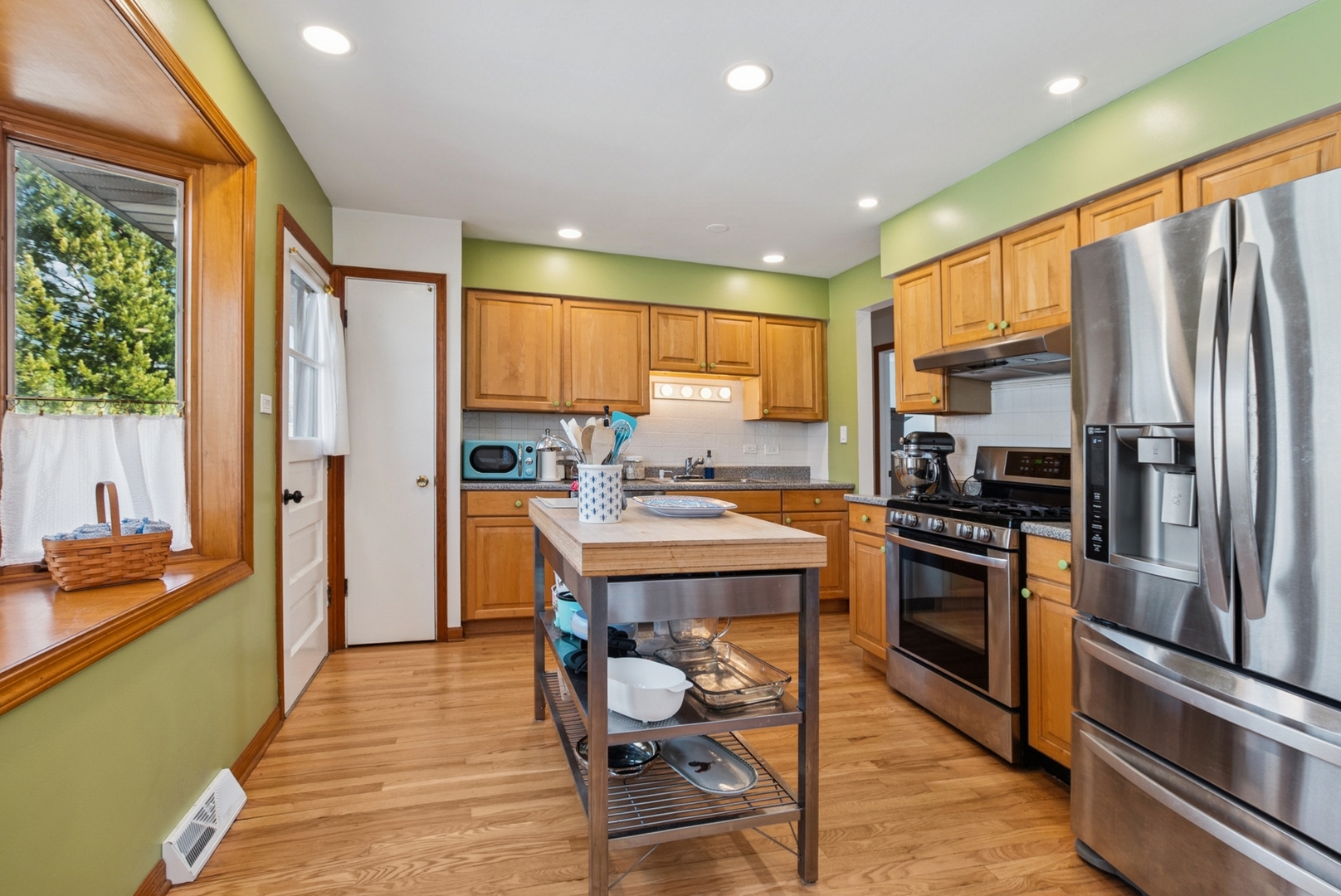 7925 Glen Lane Darien, IL 60561 - Photo 7 of 25 a kitchen with stainless steel appliances granite countertop a refrigerator a stove top oven a sink dishwasher and couches with wooden floor