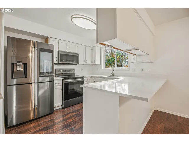 a kitchen with a sink a microwave a refrigerator and cabinets