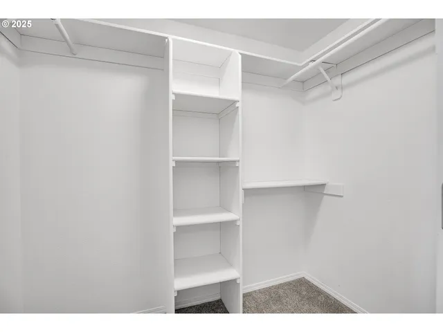 a view of walk in closet with empty racks