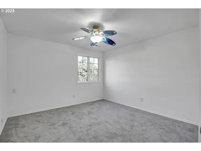 a view of an empty room with a ceiling fan