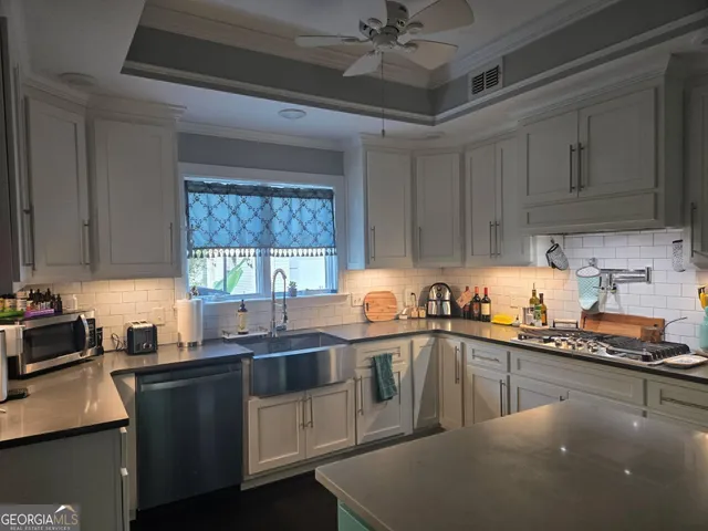 a kitchen with stainless steel appliances a sink stove and cabinets