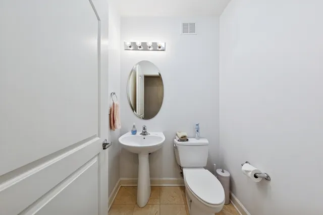 a white toilet sitting next to a bathroom sink