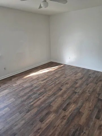 a view of an empty room with wooden floor