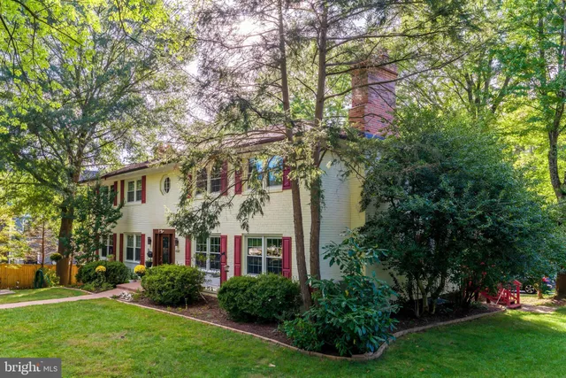 a front view of a house with a yard and tree s