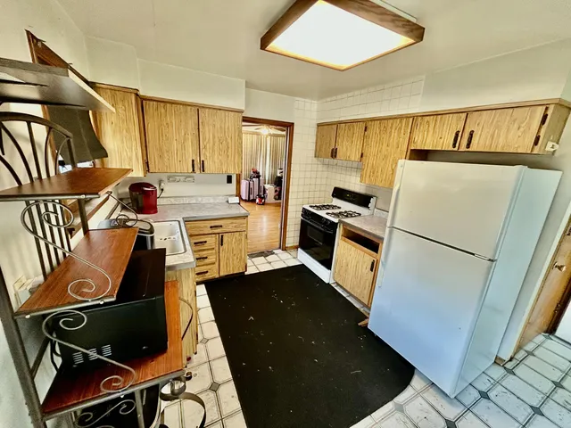 a kitchen with a refrigerator and a stove top oven