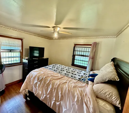a bedroom with a bed and wooden floor