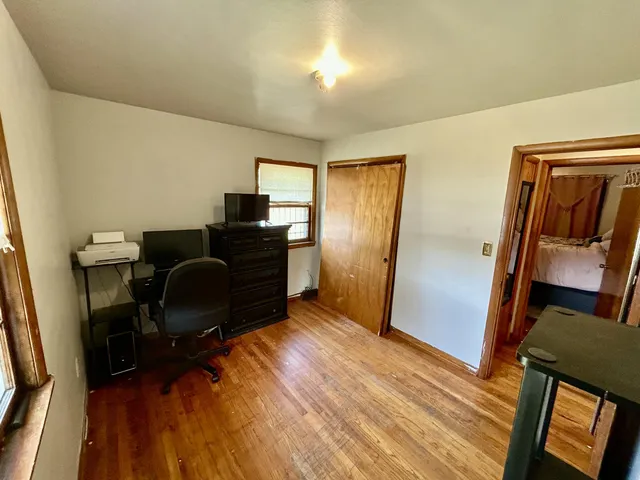 a view of a workspace with furniture and wooden floor