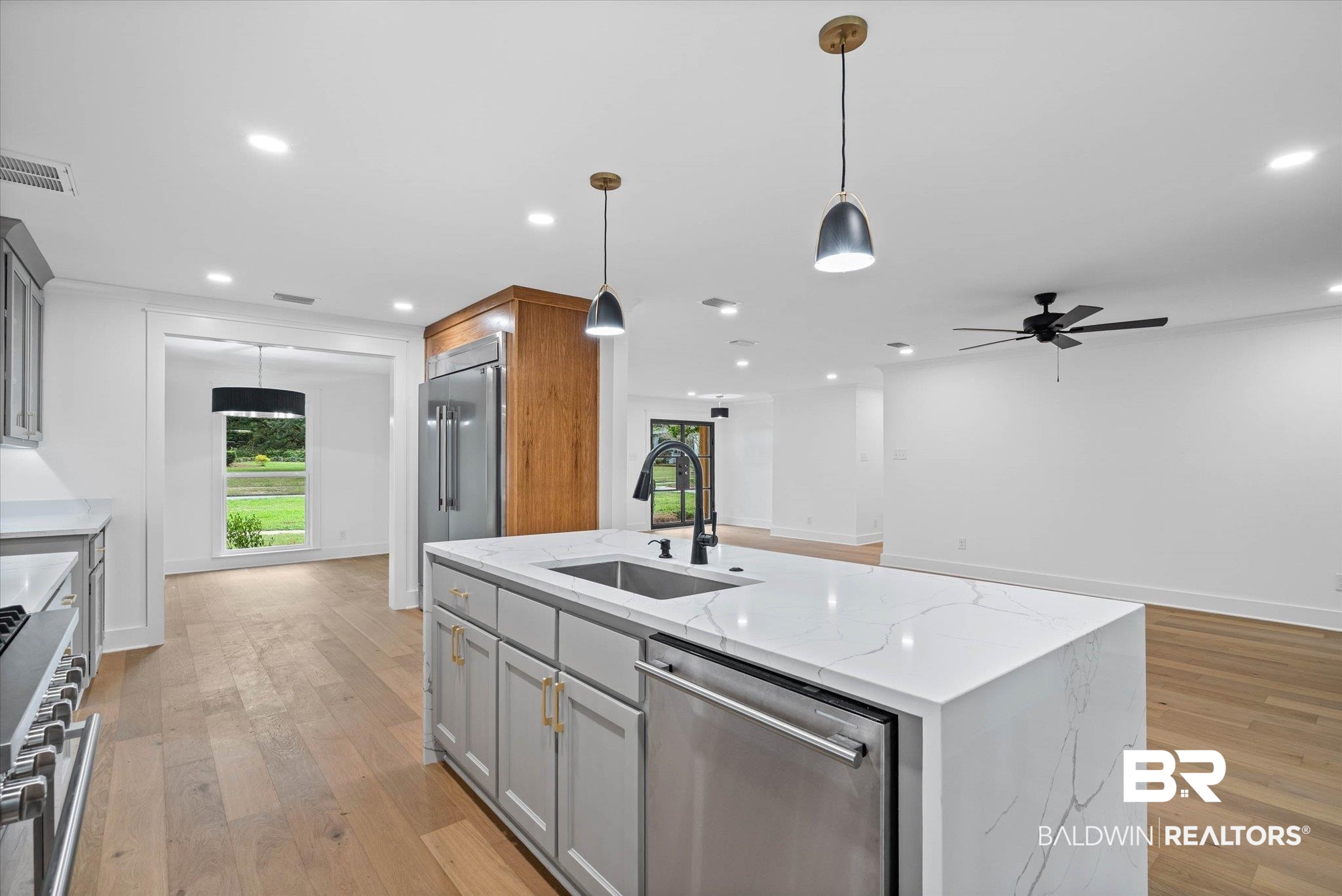 11 Schwaemmle Drive Mobile, AL 36608 - Photo 6 of 32 Kitchen featuring a kitchen island with sink, pendant lighting, light stone countertops, high quality appliances, and light wood-style floors
