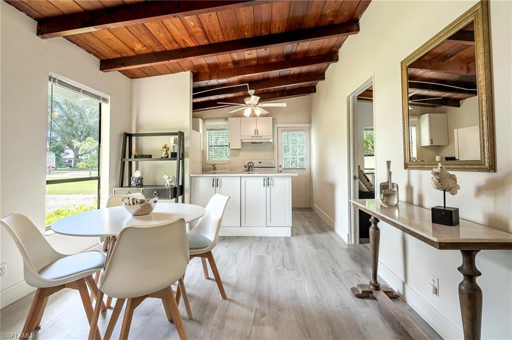 Dining area with wooden ceiling, light wood-type flooring, ceiling fan, and vaulted ceiling with beams