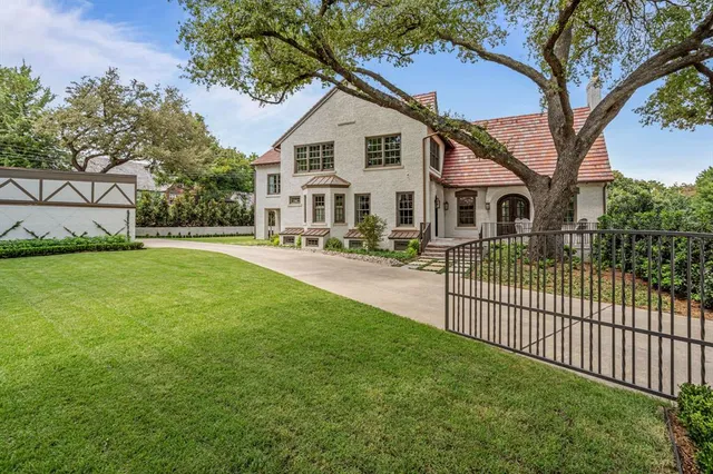 a front view of a house with a yard and trees