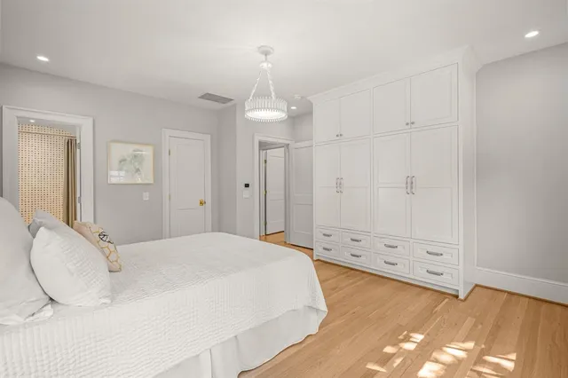 a spacious bedroom with a bed and a chandelier