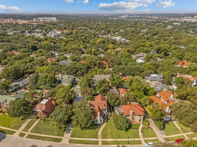 an aerial view of residential houses with outdoor space and trees