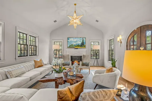 a living room with furniture a fireplace and a chandelier