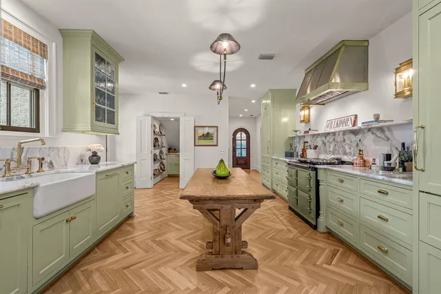 a large kitchen with kitchen island a counter space a sink and cabinets