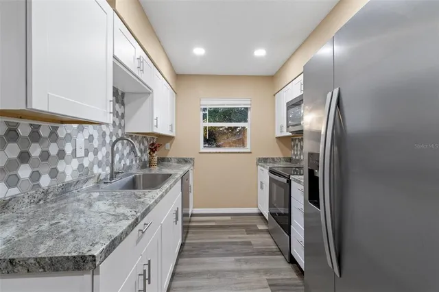 a kitchen with stainless steel appliances granite countertop a sink and stove