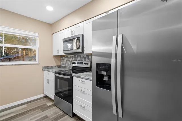 a kitchen with cabinets and stainless steel appliances