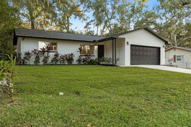 a view of a house with a yard and potted plants