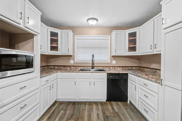 a kitchen with granite countertop a sink and cabinets
