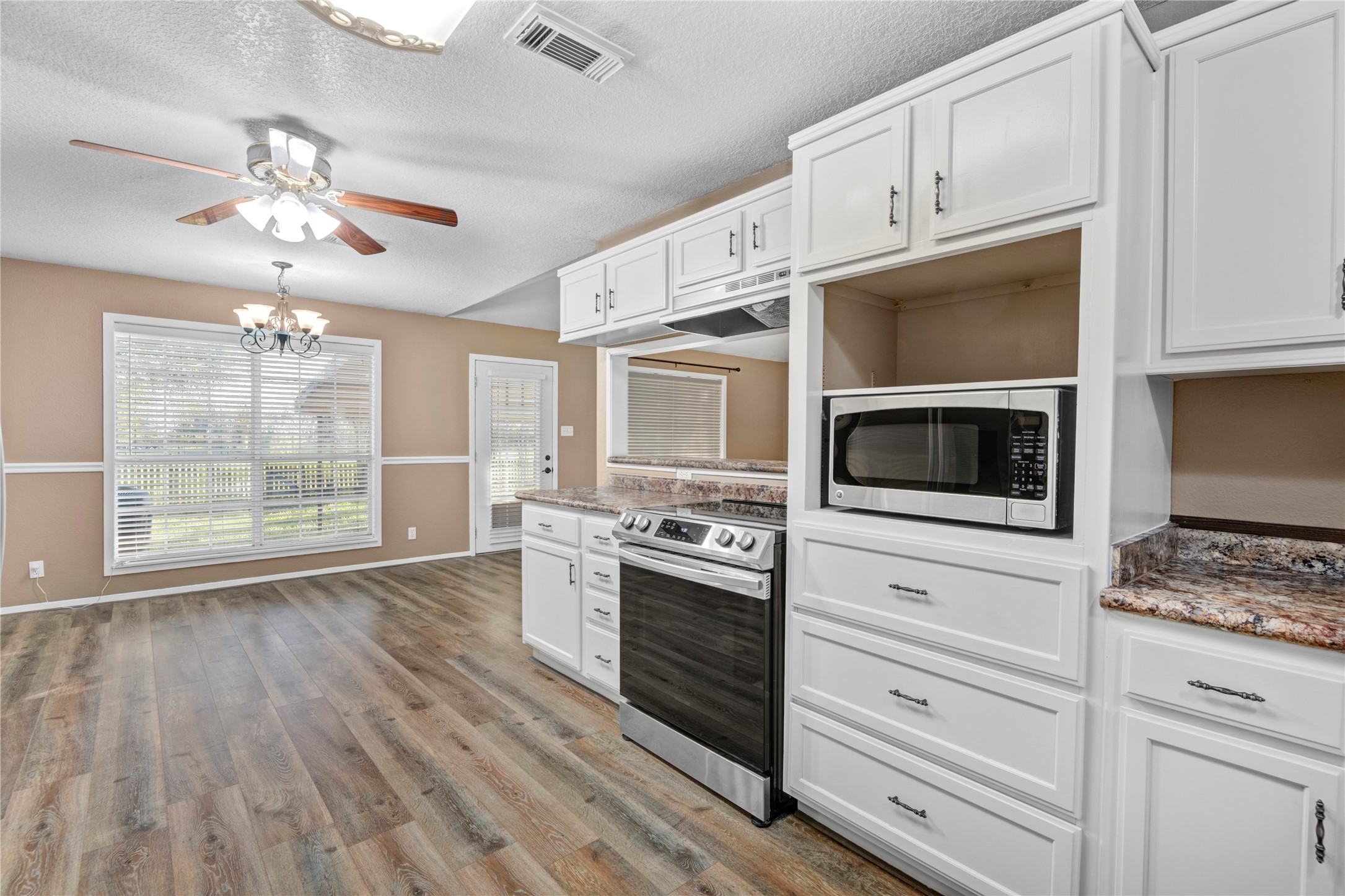 21503 Pecan Bend Road Damon, TX 77430 - Photo 17 of 39 a kitchen with granite countertop cabinets stainless steel appliances and wooden floor