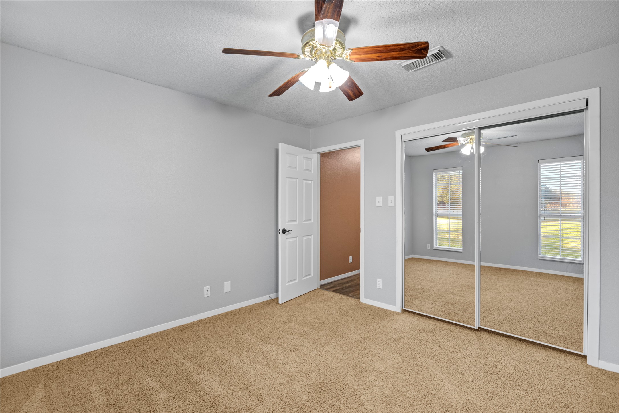 21503 Pecan Bend Road Damon, TX 77430 - Photo 30 of 39 an empty room with chandelier fan and windows