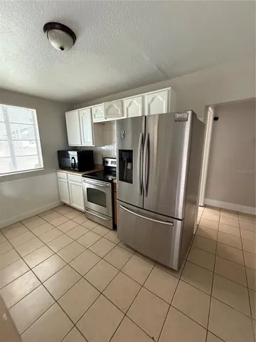 a kitchen with granite countertop a refrigerator and a sink