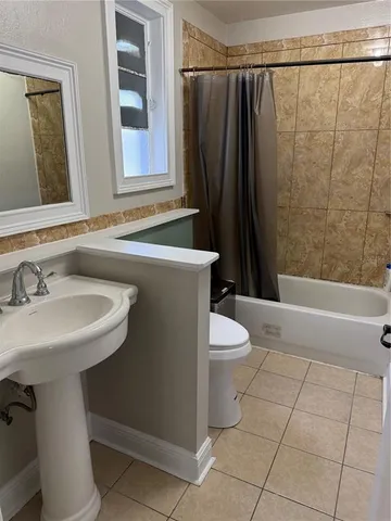 a bathroom with a sink a toilet a mirror and shower