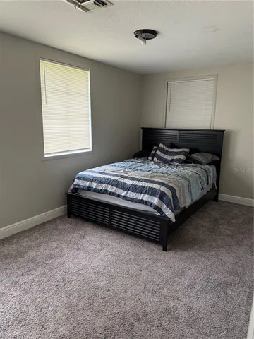 a spacious bedroom with a bed and a window