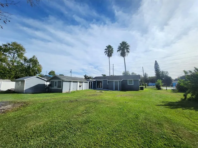 a view of a house with a big yard and a fountain