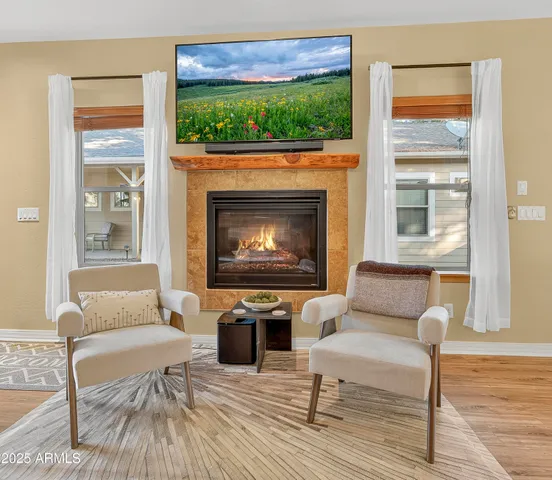 a living room with furniture a fireplace and a floor to ceiling window