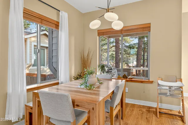 a dining room with wooden floor and a chandelier