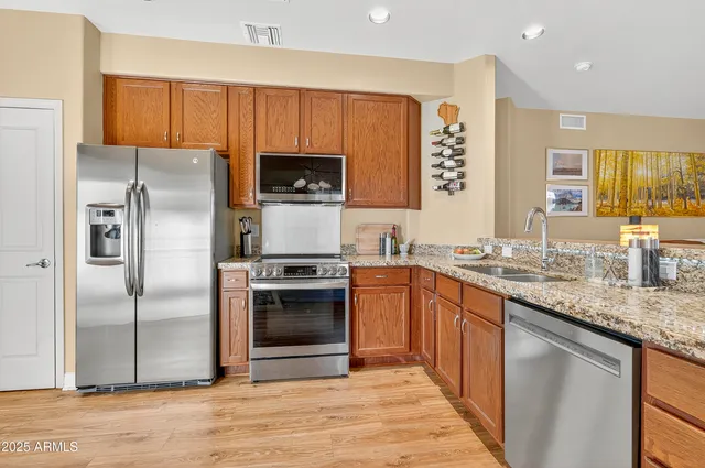 a kitchen with stainless steel appliances granite countertop a refrigerator stove and sink