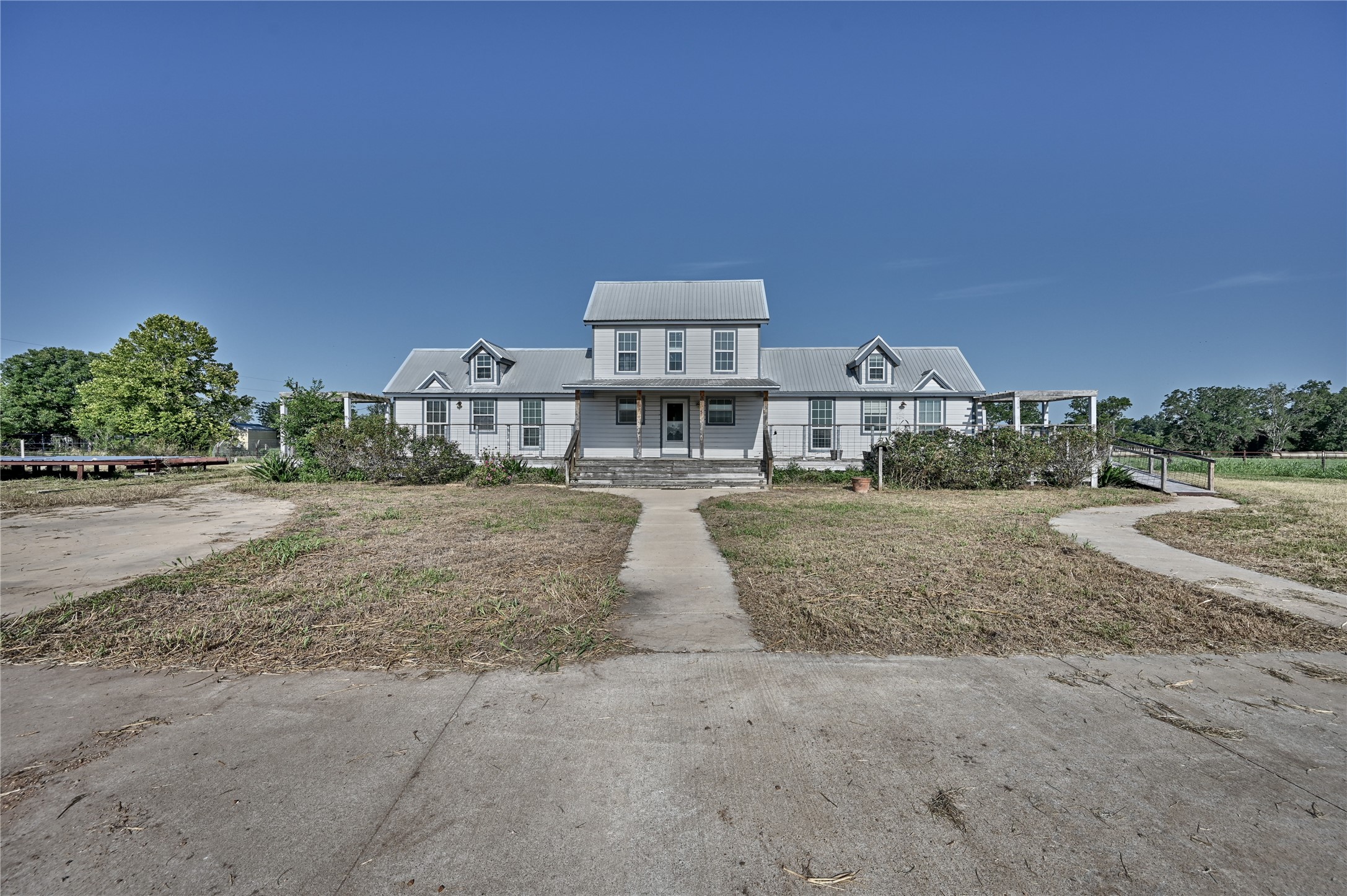 A grand, inviting home offers a welcoming presence with its expansive front facade and charming dormer windows.