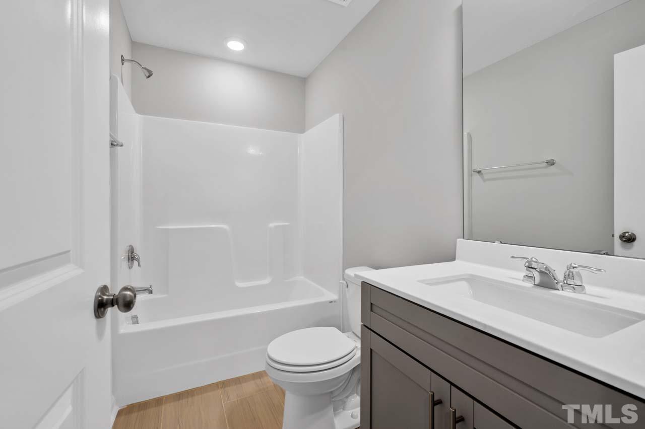 301 Devon Cliffs Drive Wake Forest, NC 27587 - Photo 16 of 26 a bathroom with a sink toilet vanity and shower