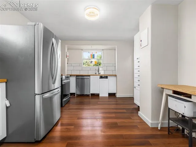 a kitchen with white cabinets and stainless steel appliances