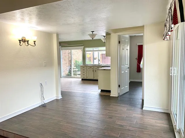 a view of a hallway with wooden floor and a cabinet