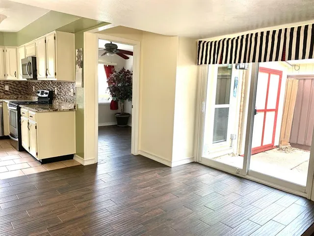 a view of a kitchen with wooden floor and a ceiling fan