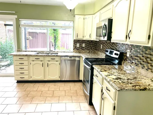 a kitchen with stainless steel appliances granite countertop a sink stove and cabinets