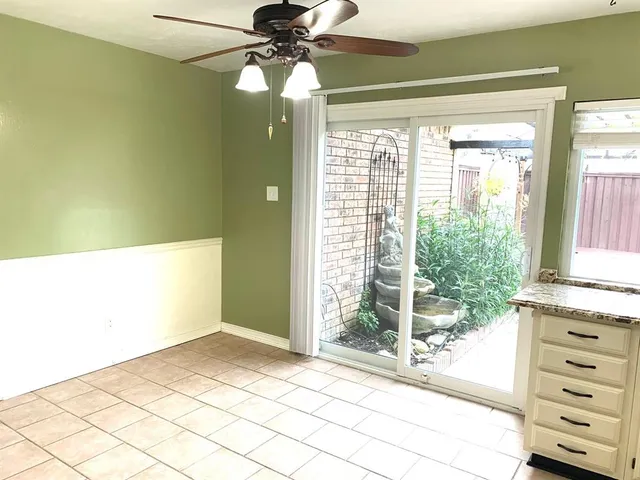 a view of a bedroom with a window and a ceiling fan