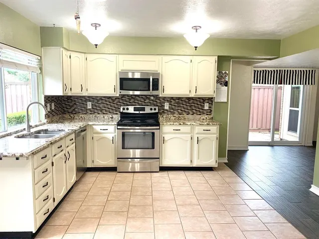 a kitchen with a stove top oven and cabinets
