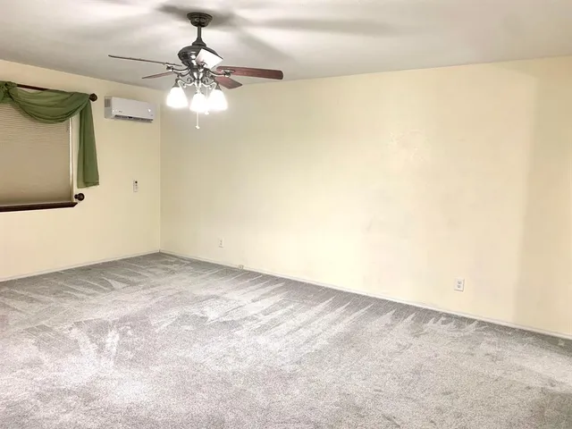 a view of a room with a ceiling fan and a window