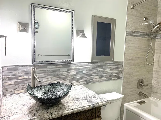 a bathroom with a granite countertop sink and a mirror