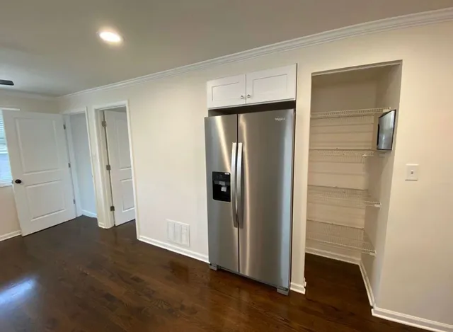 a view of a kitchen with wooden floor and windows in it