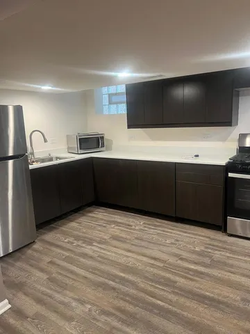 a kitchen with stainless steel appliances kitchen island wooden cabinets and sink